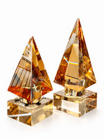 Kare kaide üzerinde amber renkli, 8 × 8 × 19 cm ve 8 × 8 × 22 cm piramit dekoratif objeler